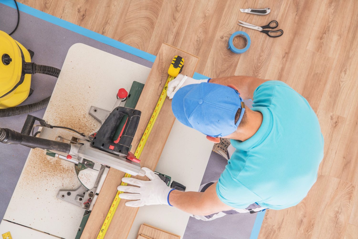 Flooring Contractor at Work. Caucasian Remodeling Worker Cutting Piece of Laminate Panel Using Circular Table Saw. Wood Like Floor Panels.